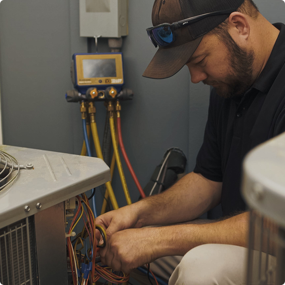 Drake Heating & Air technician checking refrigerant pressures on an air conditioning unit