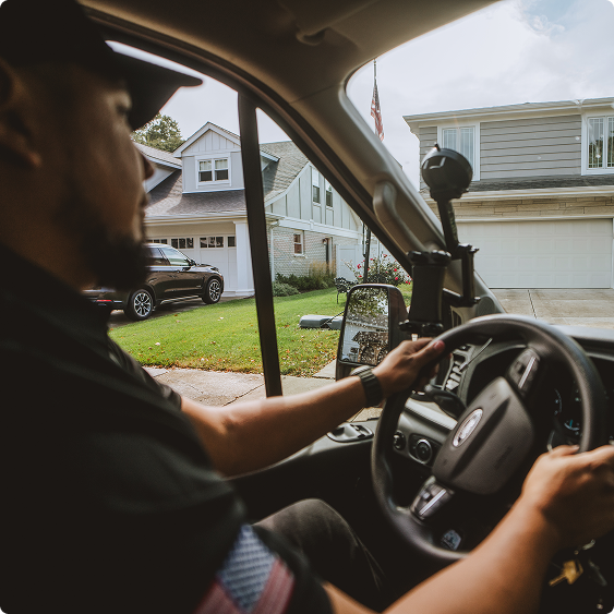 Drake Heating & Air technician driving a service van through a residential street