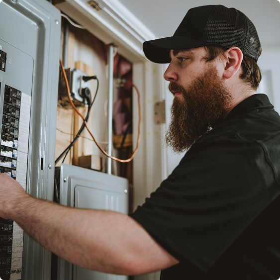 Drake Heating & Air technician working on wiring in a residential garage