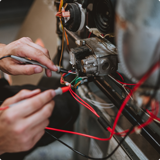 Close-up of a technician wiring a furnace blower motor with a screwdriver