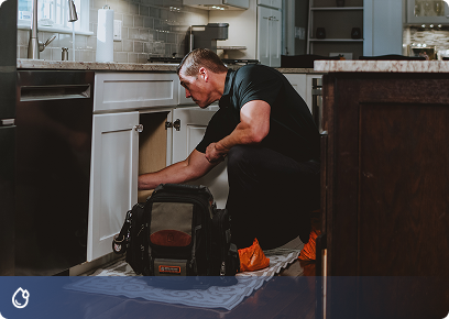 Drake-Plumbing-CTA Drake Heating & Air plumber working under a kitchen sink, linking to plumbing services